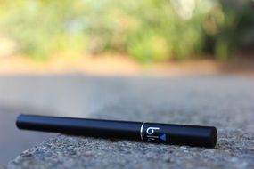 black electronic cigarette on asphalt