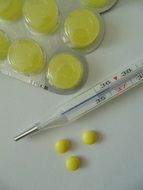 yellow pills next to the thermometer