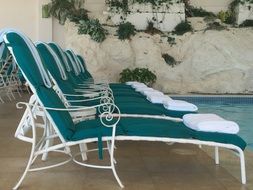 armchairs by the pool in a hotel