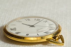 gold-framed watch on a white surface