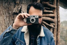 photographer holds camera near face