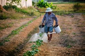 man with watering can on a farm field