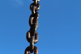 thick metal chain against a blue sky