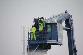 Workers are on the excavator machine