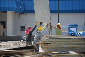 workers at a construction site near planks