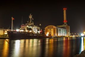 Ships in the port at night under the lights