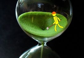 yellow figurine of a worker in an hourglass