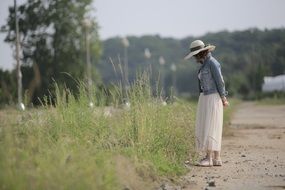 girl walks near the weeds on the street