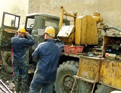 two workers at dirty Vehicle