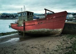 old maroon fishing boat in harbor
