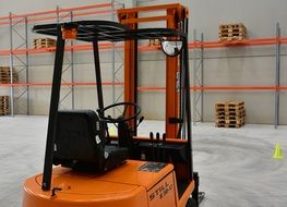 orange electric forklift in an industrial warehouse