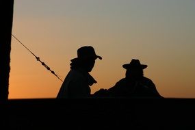 silhouettes of fishermen at sunset