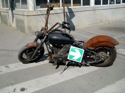 vintage motorcycle with direction sign on street
