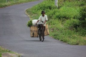 man rides a bicycle with green grass