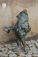 dwarf, bronze sculpture at wall, poland