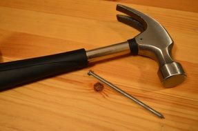 Hammer and long Nail on wooden surface