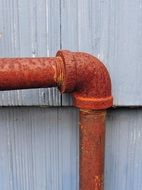 elbow of a metal pipe near the wall