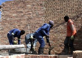 builders near a brick wall