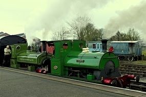 green locomotive at train station