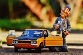 toy figure of a mechanic near the yellow car