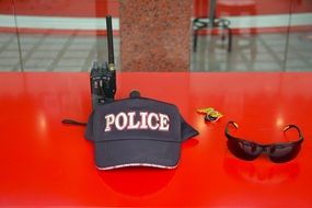 glasses, radium and a policeman cap on the table