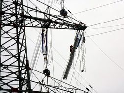 Black and white pole with live wires at background with the sky