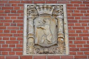 coat of arms with a bear on a brick wall