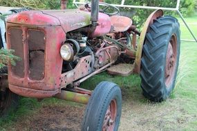 old tractor stands on green grass