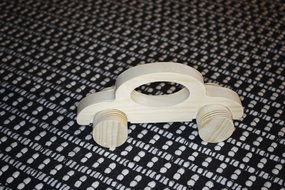 wooden toy car on black and white carpet