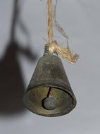 rustic bell on a rope near the gray wall