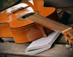 brown guitar and musical notepad