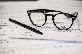 black Eyeglasses and Pen on Music Sheet