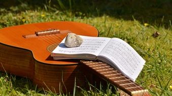 wooden guitar with a note pad on it