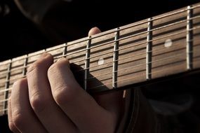the fingers on the guitar