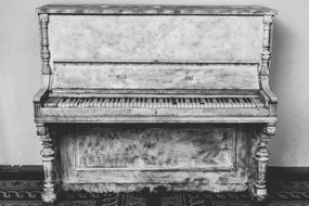 black and white image of old wooden piano