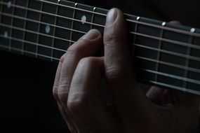 male Fingers on Guitar Strings