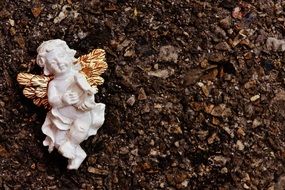 figurine of an angel on damp ground