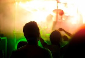 Silhouettes of crowd at a concert in the color of spotlights