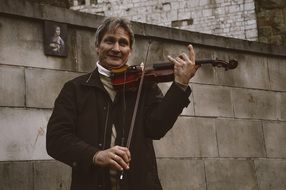 street musician plays the violin near the building in Poland