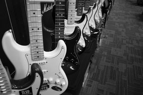 black and white photo of electric guitars in a store