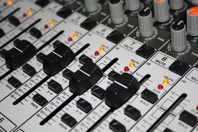 black buttons and multi-colored signals on the mixer