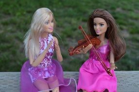 Barbie doll plays the violin near her friend