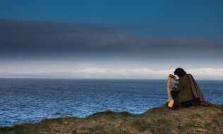 the musician plays the harp on the coast