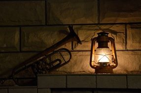 Trumpet in dusk and lantern at wall