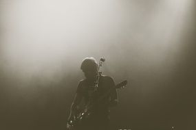 musician with a guitar on stage in a haze