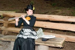 a girl in a black dress plays the flute in Canada