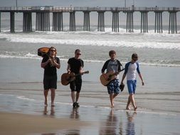 musicians with a guitar on a wide beach