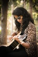 girl in sunglasses plays the guitar