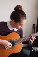 Girl is playing on the spanish guitar
