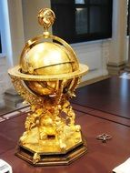 golden globe with compass in a museum